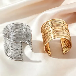 Nahaufnahme von breiten Punk-Drahtarmreifen in edlem Gold- und Silber-Finish