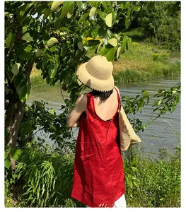 Woman wearing a Japanese style fine raffia straw sun hat in a natural park setting