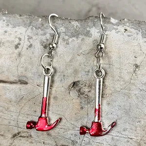 Gros plan de boucles d'oreilles marteau d'horreur d'Halloween avec taches de sang.