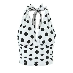 Detailansicht eines weißen Neckholder-Tops mit schwarzen Punkten und eleganter Raffung