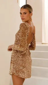 Detailansicht eines eleganten, goldfarbenen, langärmligen, rückenfreien Partykleids mit Pailletten