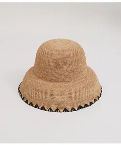 Detailed macro view of fine raffia straw hat with elegant black stitched edge decoration