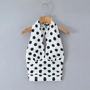 Detailansicht eines stylischen weiß-schwarz gepunkteten Halter-Tops mit plissiertem Taillendesign