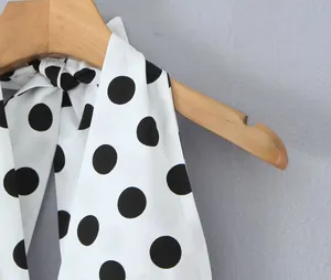 Nahaufnahme des weißen Halter-Tops mit kräftigem schwarzem Punktmuster am Holzbügel