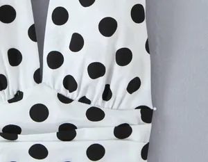 Nahaufnahme eines weißen Halter-Tops mit großen schwarzen Punkten und Falten-Detail