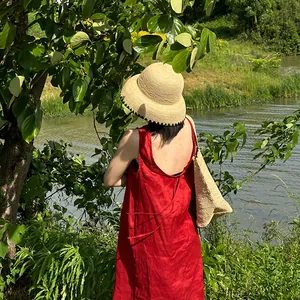 Handwoven vintage raffia straw dome bucket hat for women shown in a scenic outdoor sunlit setting