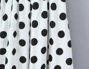 Detailaufnahme des klassischen schwarz-weißen Polka-Dot-Musters auf weichem Stoff.