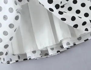 Detailaufnahme des gepunkteten Rocksaums mit weißem Innenfutter und feiner Textur