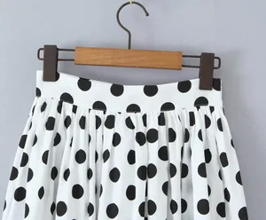 Detailaufnahme eines weißen High-Waist-Rocks mit klassischem schwarzen Polka-Dot-Muster