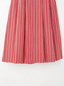Détail en gros plan de l'ourlet d'une jupe midi en coton à rayures rouges et blanches.