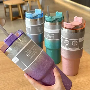 Close-up of a glitter gradient insulated tumbler held in hand with others in the background