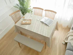 Modern rectangular tablecloth with blue daisy print and tassel fringe on wooden table