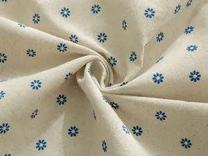 Macro detail of beige cotton linen fabric with small blue daisy floral print pattern