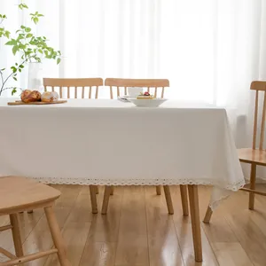 White rectangular tablecloth with elegant lace trim in a bright pastoral dining setting.