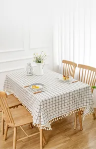 Primer plano de un mantel de lino a cuadros minimalista con flecos decorativos blancos
