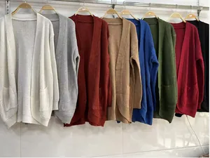 Detail view of multi-colored knitted cardigans with curved hems and open fronts