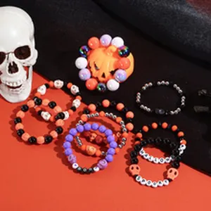 Detail van Halloween kralenarmbanden met pompoen en schedel bedeltjes voor feestjes.