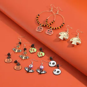 Detail van Halloween-oorbellen met pompoen-, schedel- en spookhangers met kralen.