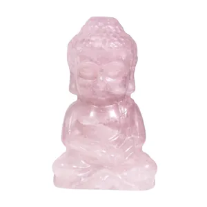 Nahaufnahme einer handgeschnitzten Baby-Buddha-Figur aus rosa Rosenquarz Edelstein