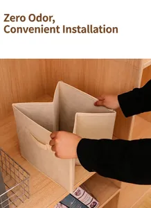 Detail view of unfolding a beige foldable non-woven fabric storage box inside a wooden closet