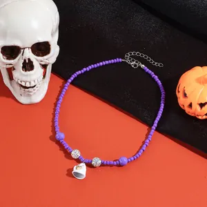 Gedetailleerde close-up van een paarse kralenketting voor Halloween met spookhanger