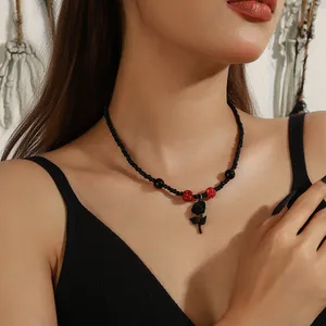 Detailopname van een gotische Halloween-ketting met zwarte kralen en een rooshanger.