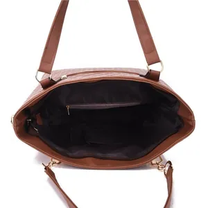 Interior view of brown quilted tote bag with spacious compartment and zipper pockets