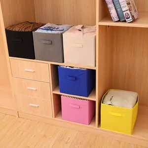 Cajas de almacenamiento plegables de tela no tejida en varios colores en un armario de madera