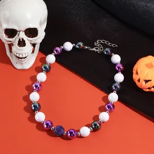 Detailweergave van Halloween kralenketting met paarse en witte parels op feestelijke basis.