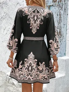 Vista posteriore di un mini abito boho nero con stampa paisley e maniche a lanterna.