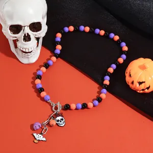 Detailopname van Halloween kralenketting met hangers van pompoen, vleermuis en schedel