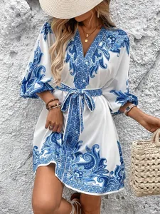 Dettaglio di un vestito estivo a fiori con stampa paisley blu e cintura regolabile in vita