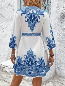 Vista posteriore di un abito boho bianco con stampa paisley blu e laccio in vita.
