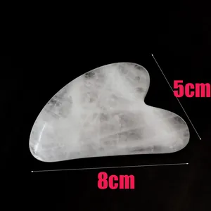 Gros plan d'un outil Gua Sha en jade blanc en forme de cœur mesurant 8cm x 5cm
