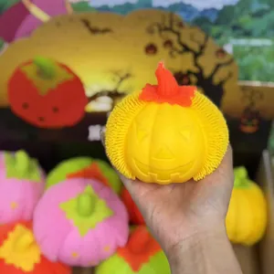 Close-up detail of yellow glowing Halloween pumpkin squeeze toy with textured sides