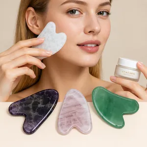 Model demonstrating various natural heart-shaped crystal Gua Sha massage tools for skin care.