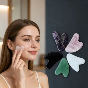 Asian female model demonstrating a heart-shaped rose quartz gua sha tool for facial skincare