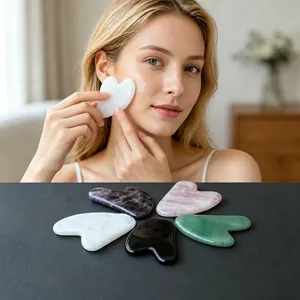 Asian woman using heart-shaped natural stone Gua Sha tool for facial massage to revitalizing skin