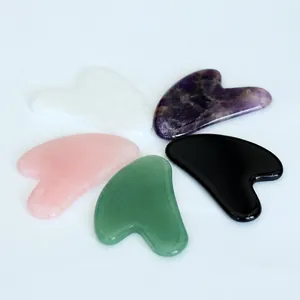 Detailed close-up showing five natural jade heart-shaped gua sha scraping massage tools