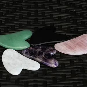 Detailed view of five multi-colored natural stone heart-shaped Gua Sha scraping tools