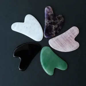 Heart-shaped Gua Sha tools in amethyst, rose quartz, green aventurine, and obsidian