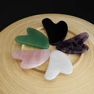 Detailed view of five natural stone heart-shaped gua sha tools in different colors