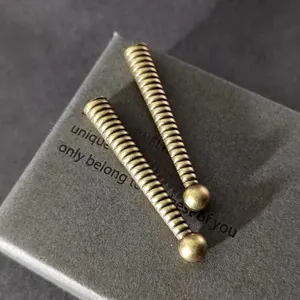 Primer plano de terminales de cordón en bronce antiguo roscados con punta de bola