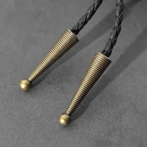 Primer plano de puntas metálicas roscadas de bronce antiguo para cordones de corbata Bolo