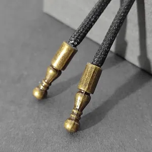 Primer plano de puntas de corbata Bolo en bronce antiguo con textura roscada
