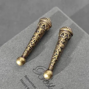 Detalle de terminales de cordón en bronce antiguo con patrones florales para lazos bolo.