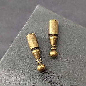 Primer plano de puntas de cordón bolo de bronce vintage sobre fondo gris
