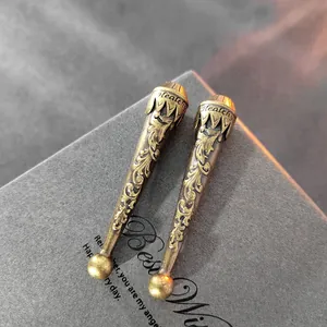Terminales de cordón de bronce antiguo con intrincados motivos florales, detalle