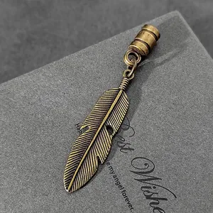 Primer plano detallado de un colgante de pluma de bronce antiguo para la creación de joyas DIY