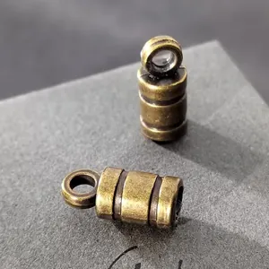 Primer plano de terminal de cordón cilíndrico de bronce antiguo con anillo para DIY